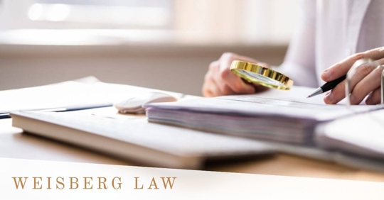 a person writing on a book, while using a magnifying lens